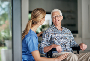 A caregiver providing Sour Lake home care helps an older man in a wheelchair.