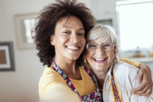 A female caregiver providing Silsbee home care hugs a happy senior client.